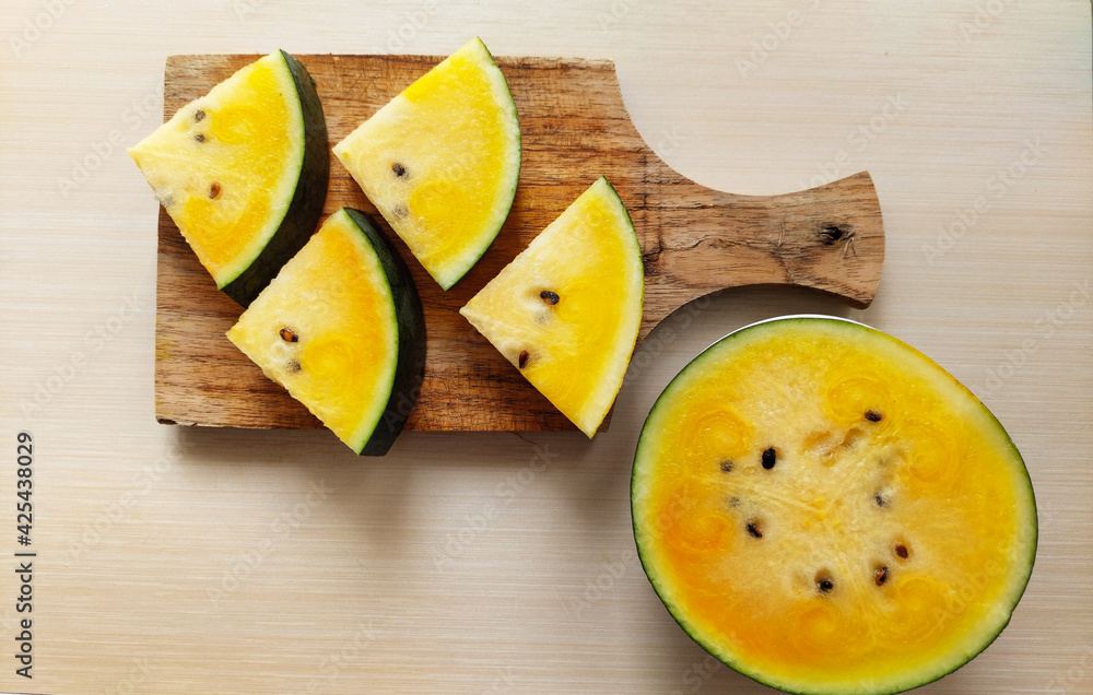 Slice of yellow watermelon on cutting board Slice of yellow watermelon on cutting board