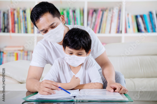 Father in mask accompany son to study from home