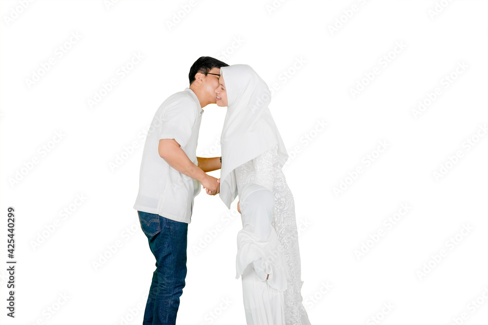 Man kissing his wife during Eid Mubarak on studio Man kissing his wife during Eid Mubarak on studio