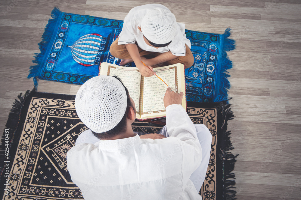 Φωτογραφία Muslim child learning to read Quran with his father