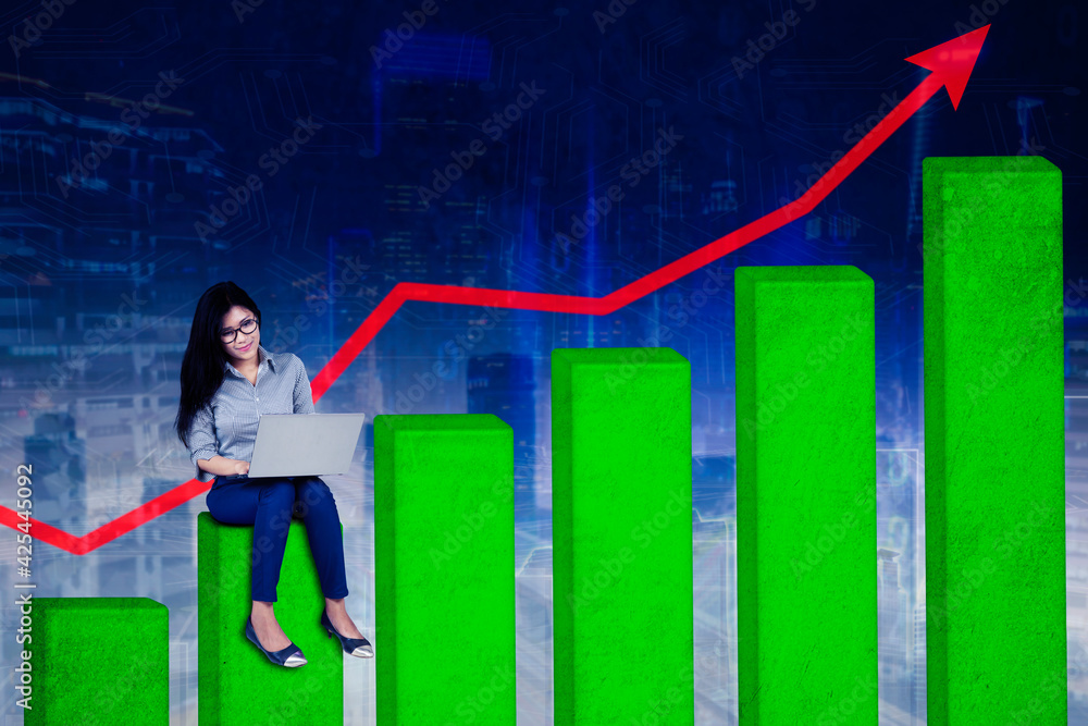 Businesswoman working with laptop on growth graph Businesswoman working with laptop on growth graph