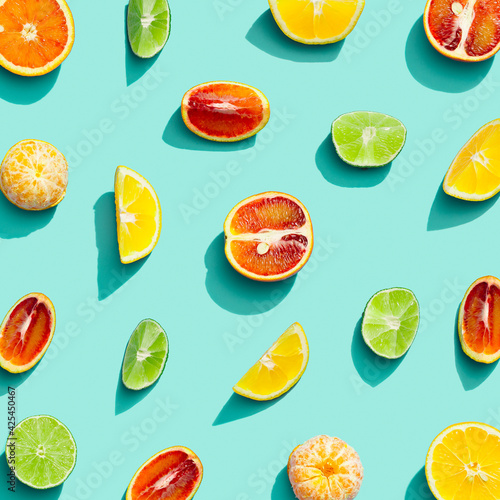 Fototapeta Naklejka Na Ścianę i Meble -  Summer fruits top view, bright juice citrus, lemon, orange, tangerine and lime on blue background. Healthy fruit food.