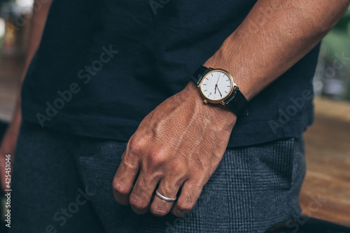 fashionable wearing stylish looking at luxury watch on hand check the time at workplace.concept for managing time organization working,punctuality,appointment
