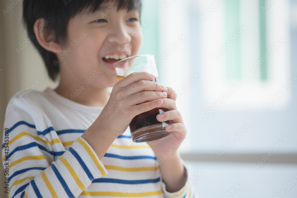 Little asian boy drinking soft drink coca cola soda Little asian boy drinking soft drink coca cola soda