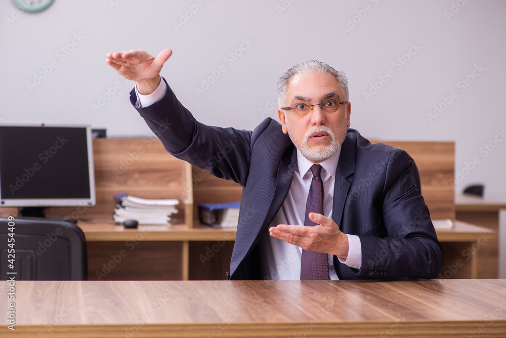Old businessman employee sitting in the office Old businessman employee sitting in the office