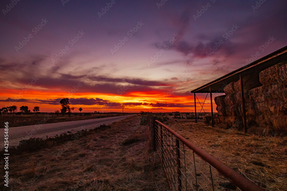 Hay shed on country farm during vibrant sunset Hay shed on country farm during vibrant sunset
