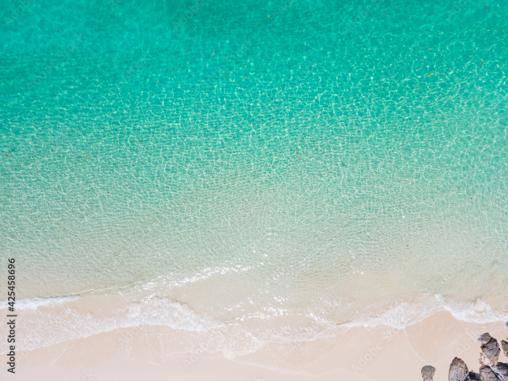 Obraz premium Aerial view nature summer sea waves in top-down drone shot perspective. Crashing wave line in Phuket South of Thailand. Andaman sea with foamy white texture.