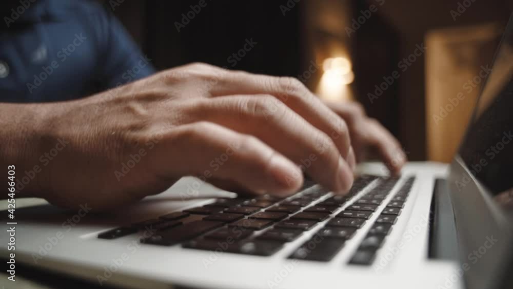 Close up of man's hands typing on a laptop computer doing home office Close up of man's hands typing on a laptop computer doing home office
