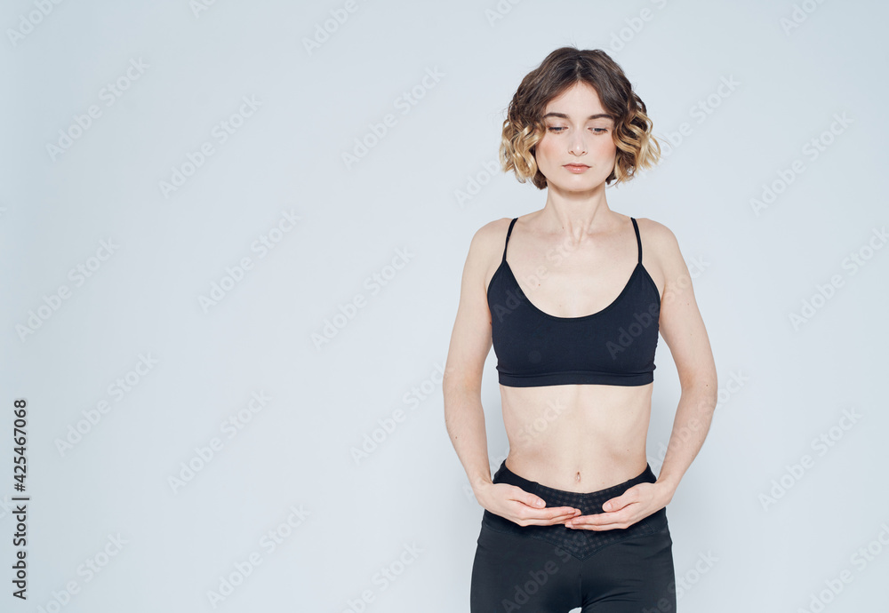 Woman in sportswear is engaged in fitness on a light background cropped view Woman in sportswear is engaged in fitness on a light background cropped view