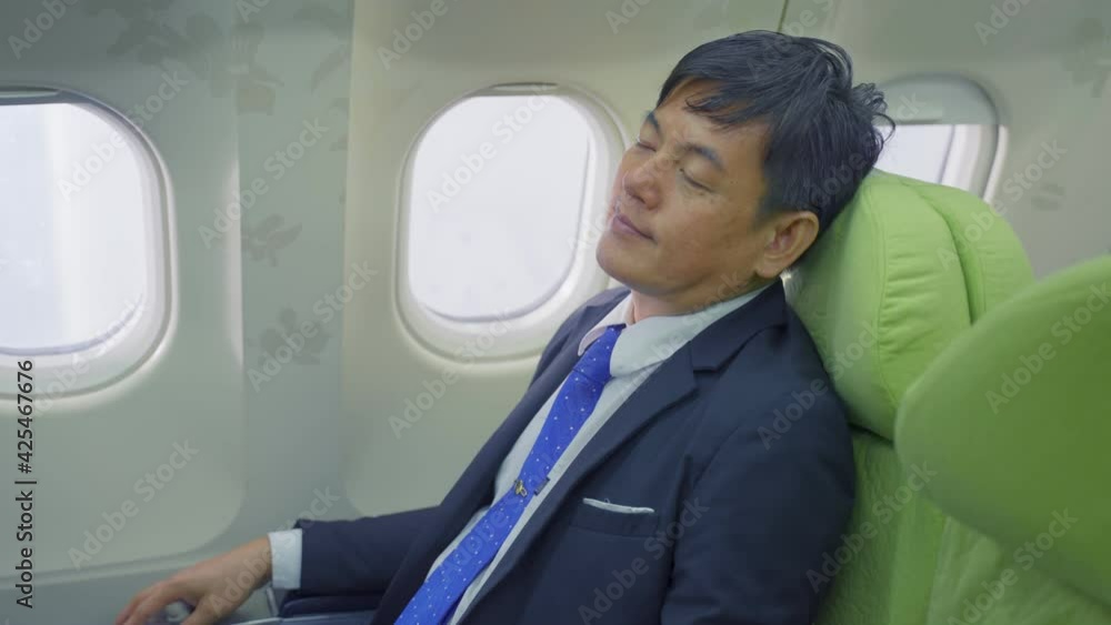 Asian businessman passenger feeling relax while sitting on board. Asian businessman passenger feeling relax while sitting on board.