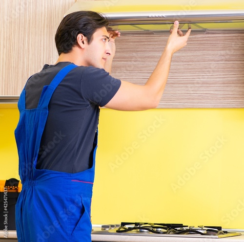 Young service contractor assembling kitchen furniture