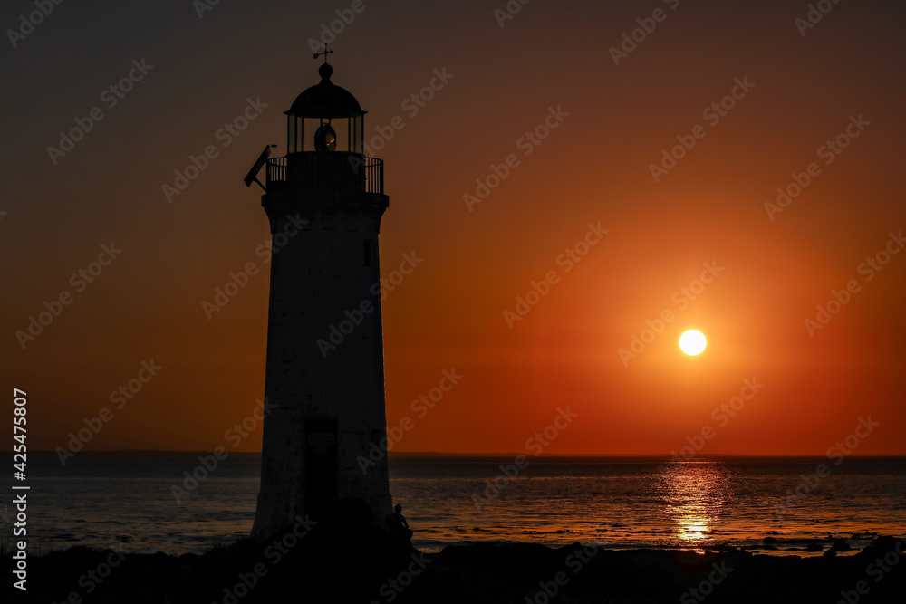 Lighthouse sunrise over ocean 