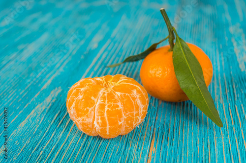 orange tangerine with leaf on turquoise wooden table