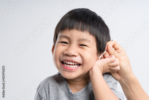 Asian mother cleaning her 4 years old boy ear with cotton swab