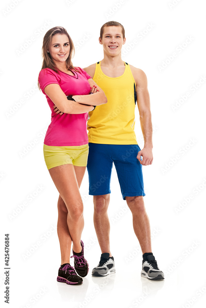 Full photo of fit pretty man and woman posing in sportswear and smiling at camera Full photo of fit pretty man and woman posing in sportswear and smiling at camera