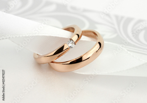 Two wedding rings with diamond on grey background