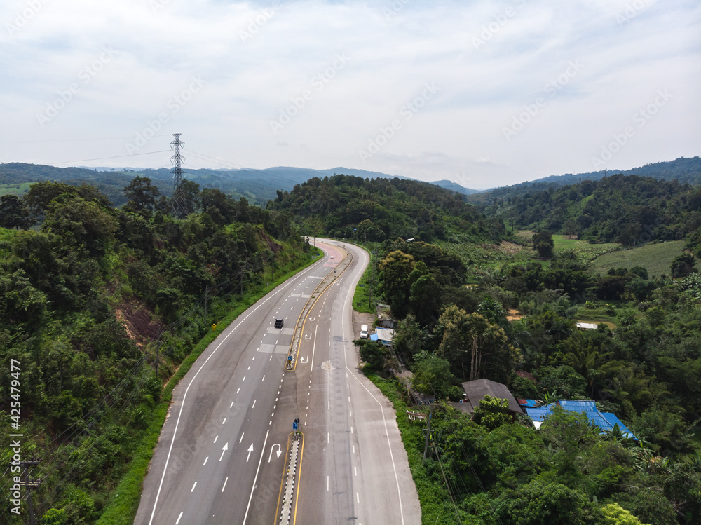 Obraz premium Asphalt road through mountain and forest