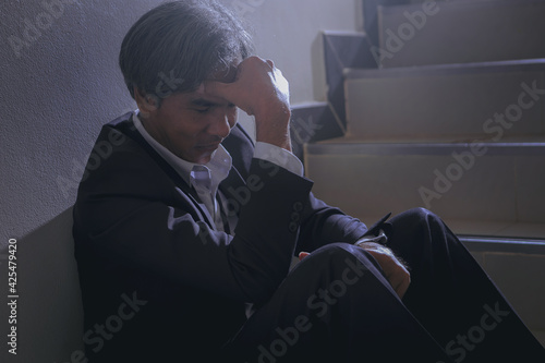 Senior businessman is disappointed and seriously by business results report. Bad investment or economic crisis concept.