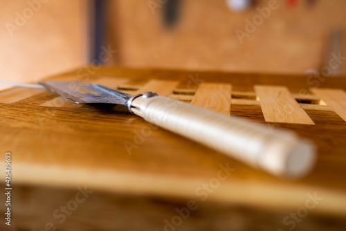 Japanese dozuki hand saw on hand crafted oak live edge  tabletop with alderwood inserts . photo