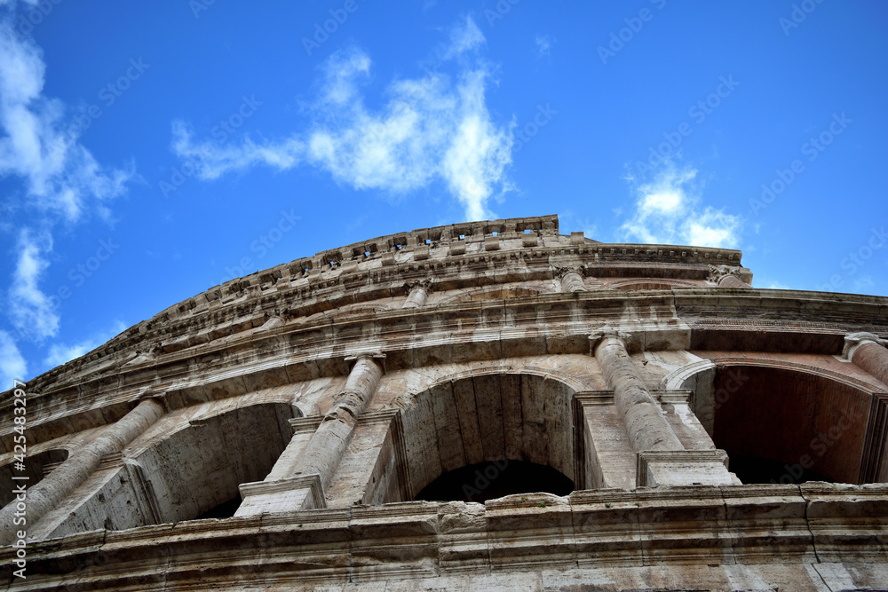 exterior of Colosseum on blue sky with white clouds background - Rome, Italy, Europe