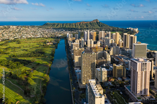 Aerial view of Waikiki district and Diamond Head Mountain at sunset. Tall buildings by Ala Wai Canal. Oahu Island, Hawaii © marchello74