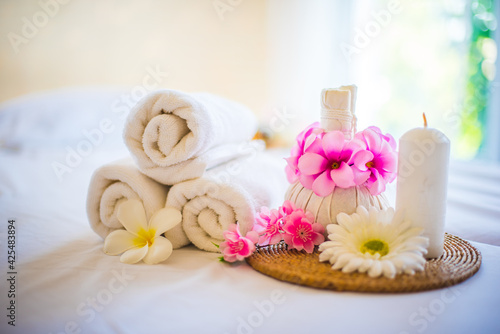 Towel and compress  it decorated with a pink flower. Spa composition on massage table