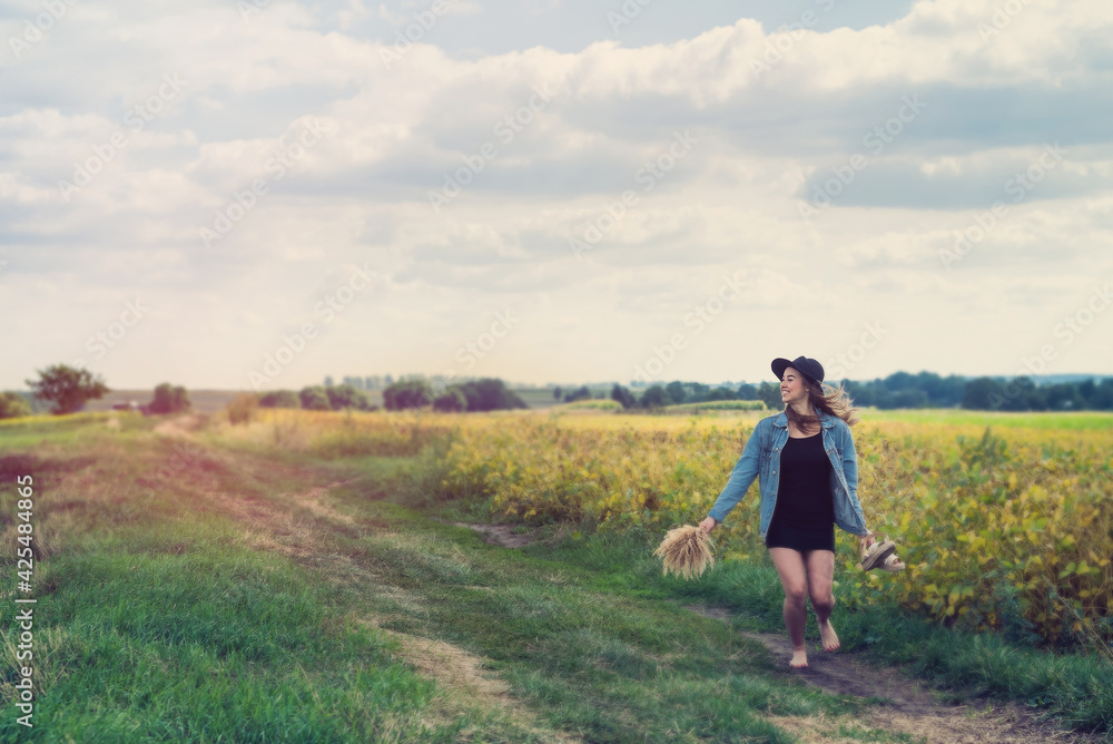 incredibly beautiful young woman posing in a rural field in summer
