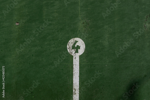 fronton wall in the Basque ball sport, in which the game marks are painted with the number 4 painted in negative in a white circle on a green background © Javier Peribáñez
