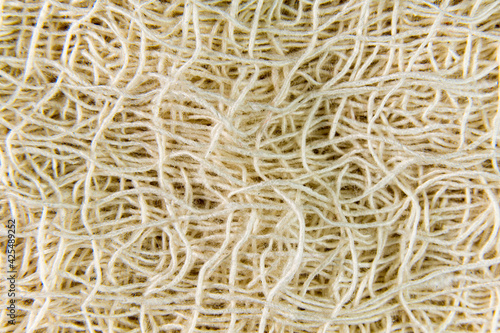 A close up of a white net or string. A texture macro photography that shows the intricate and delicate design of the material