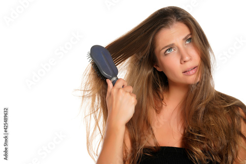 Young nervous womanbrusing her hair with hairbrush