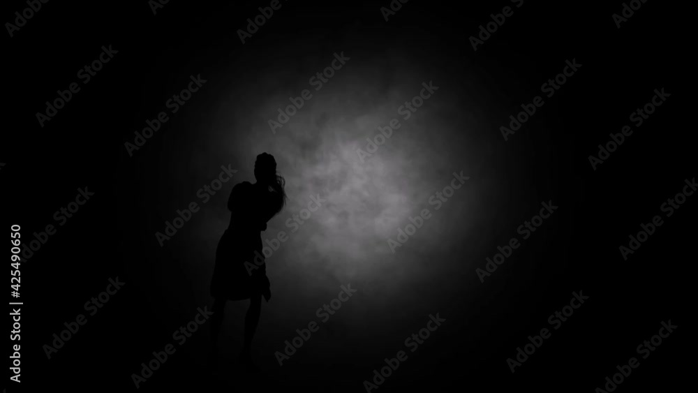 A modern youth dance performed by a graceful and sexy female silhouette, in the smoke against the backdrop of spotlights. A modern youth dance performed by a graceful and sexy female silhouette, in the smoke against the backdrop of spotlights.