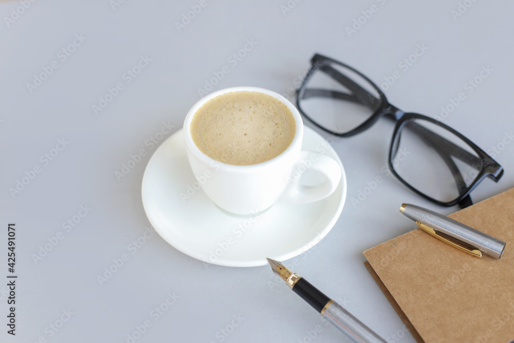 gray background with coffee cup, pen and glasses. Top view with copy space gray background with coffee cup, pen and glasses. Top view with copy space