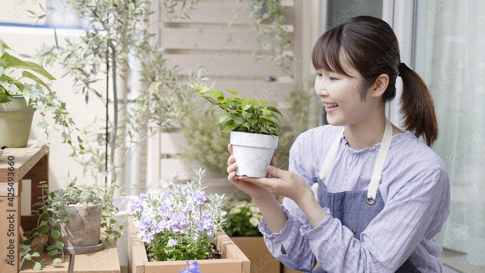 ベランダガーデニングをする笑顔の女性 ベランダガーデニングをする笑顔の女性
