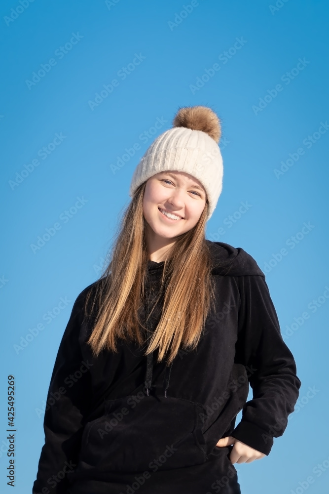 Hübsches junges Teenager Mädchen posiert im hellen, weißen Schnee vor blauem Himmel Hübsches junges Teenager Mädchen posiert im hellen, weißen Schnee vor blauem Himmel
