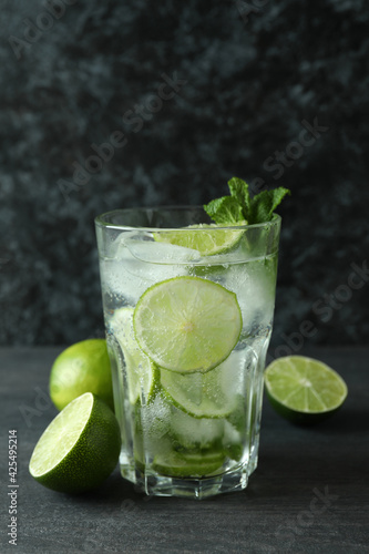 Glass of mojito cocktail and ingredient on dark wooden table