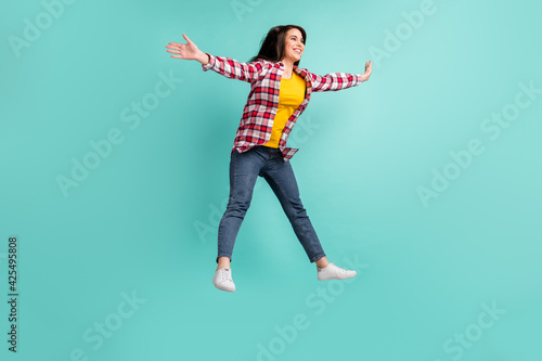 Full length photo of positive funky woman jump up look empty space star shape isolated on teal color background
