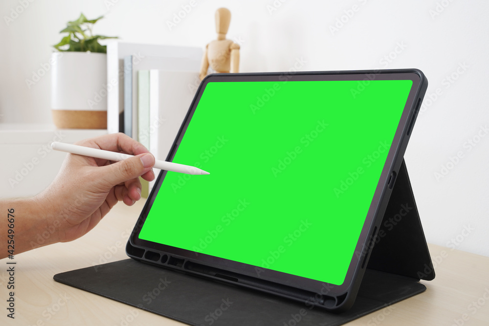 Fototapeta premium Designer using stylus pen with blank screen display on workspace.