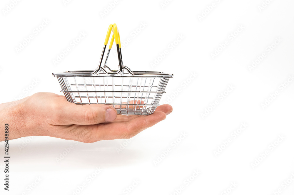 empty iron shopping basket in the supermarket on the palm of a hand on a white background side view isolated
