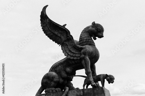 Black and white image of a sculpture of a mythological animal on a pedestal