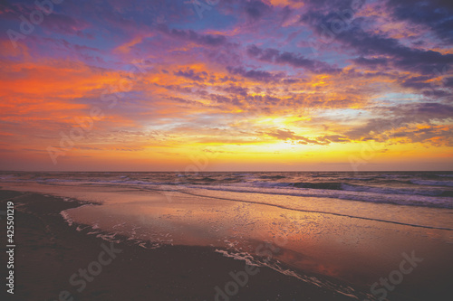 Seascape in the early morning. Sunrise over the sea. Sandy beach with the beautiful dramatic sky during sunrise. Nature landscape