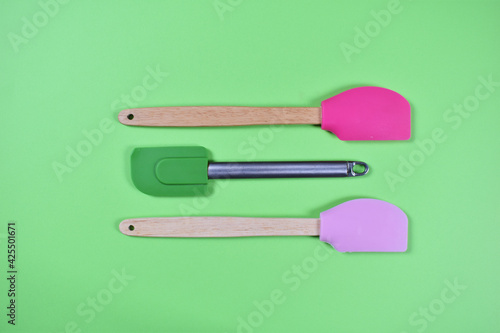 Kitchen tools for baking spoons brush on green background
