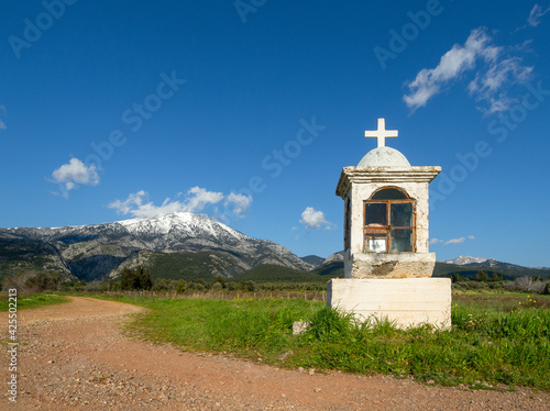 Panoramic view of snow covered mountain Dirfys, church Candelakia  and sky with clouds on on the island of Evia, Greece photo