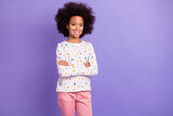Photo of charming afro american little girl crossed hands wear pink pants isolated on violet color background
