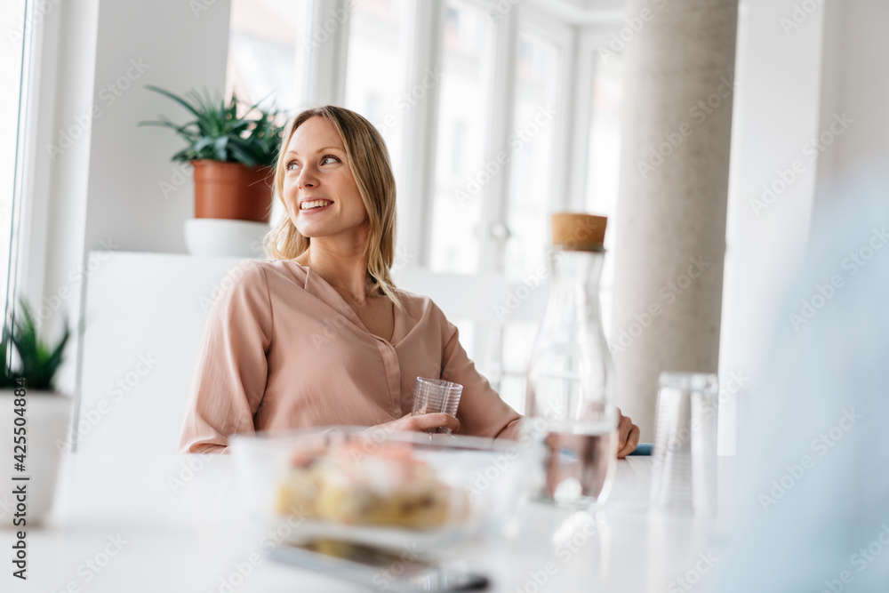 Happy young woman relaxing enjoying refreshments in high key room