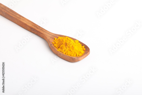Turmeric in wooden spoon on white background.