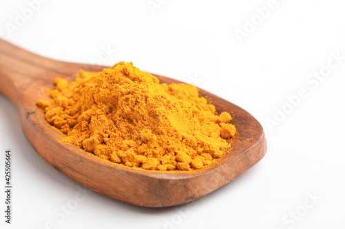 Turmeric in wooden spoon on white background.