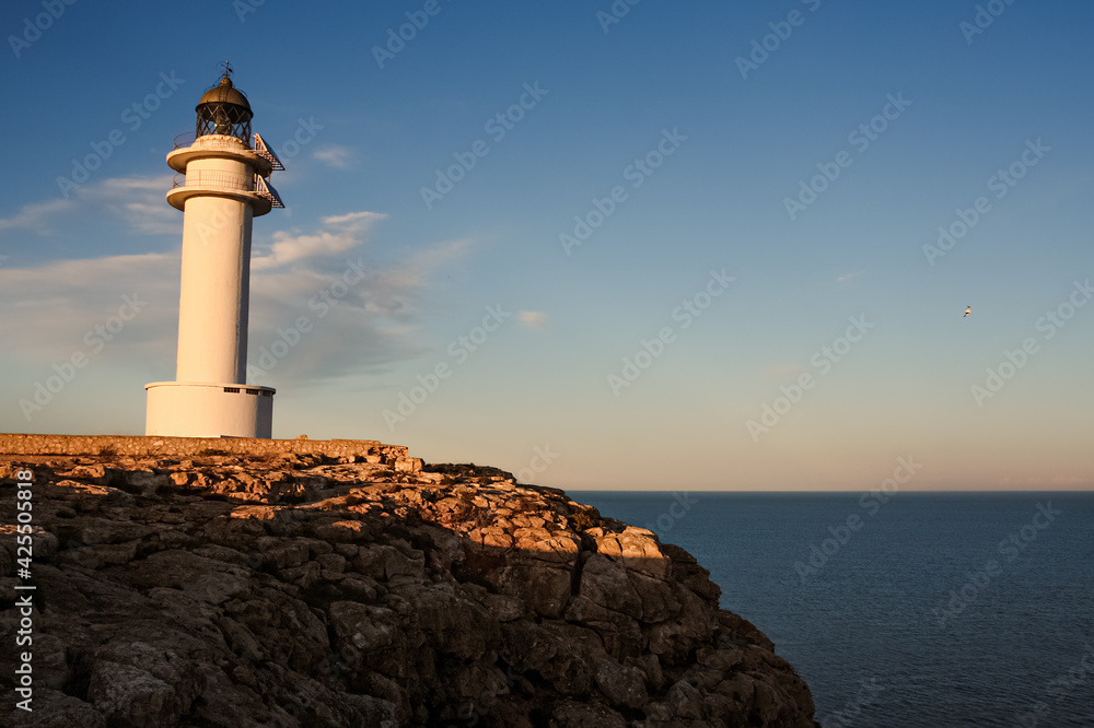 lighthouse at the coast of Formentera during sunset, beautiful blue sky