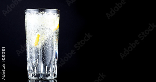 splash in a glass with lemon on a black background