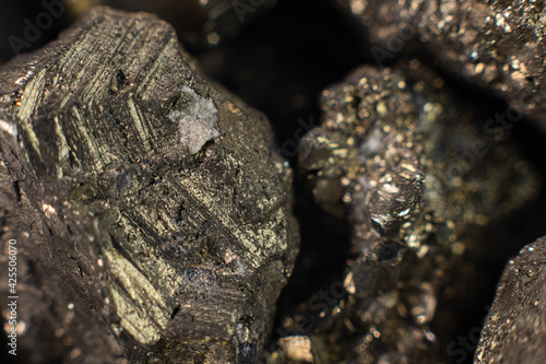 Macro photograph of natural pyrite crystal cluster, extreme close-up of iron sulfide mineral with metallic brass-yellow luster and cubic geological structure