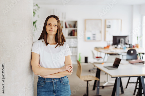 Serious determined casual middle-aged businesswoman with folded arms
